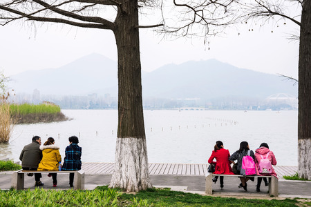 NANJING, CHINA- MARCH 17: Chinese people sitting and talking by Xuanwu lake tourist area on March 17, 2016 in Nanjing.のeditorial素材