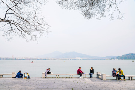 NANJING, CHINA- MARCH 17: Chinese people sitting and talking by Xuanwu lake tourist area in the afternoon on March 17, 2016 in Nanjing.のeditorial素材