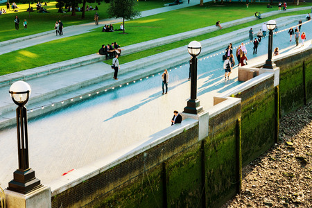 LONDON - JULY 06, 2016: People walking riverside by the Thames river which is a popular tourist area on a sunny day taken from Tower bridge on July 06, 2016 in Londonのeditorial素材