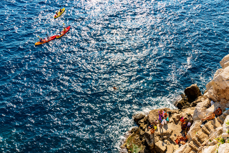 DUBROVNIK, CROATIA - SEPTEMBER 22: View of a rocky beach with tourists and kayakers in the sea on September 22, 2016 in Dubrovnikのeditorial素材