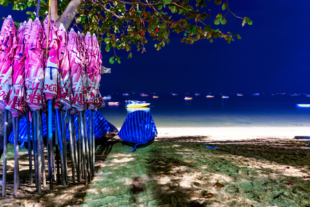 PATTAYA, THAILAND - JANUARY 17: This is Pattaya beach at night which is the main beach in the center of Pattaya with umbrellas and boats in the background January 17, 2017 in Pattayaのeditorial素材