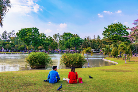 BANGKOK, THAILAND - FEBRUARY 04: Couple sitting by the lake in Chatuchak park a famous park in Bangkok on February 04, 2017 in Bangkokのeditorial素材