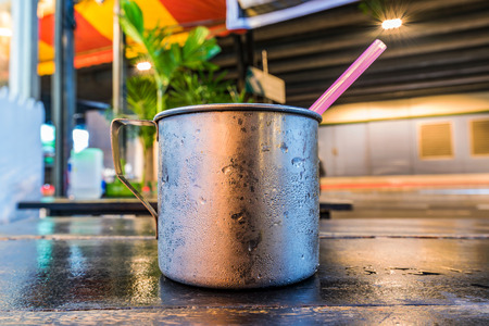 Metal cup on a table at night in Thailandの写真素材