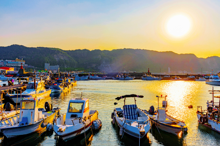 View of fishing boats docked in a fishing village with sunsetのeditorial素材
