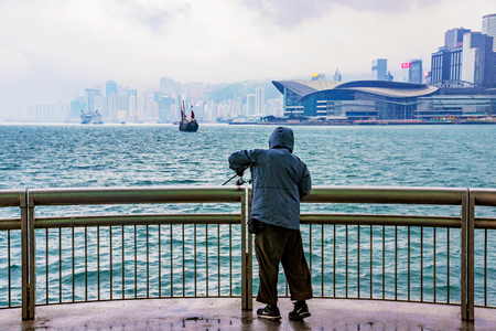 HONG KONG, CHINA - APRIL 25: This is a fisherman trying to catch a fish during a storm in the downtown area of Hong Kong on April 25, 2017 in Hong Kongのeditorial素材