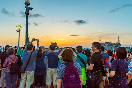TAIPEI, TAIWAN - MAY 29: Tourists taking photos of the sunset from a pier in the Fisherman's Wharf area of Tamsui on May 29, 2017 in Taipeiのeditorial素材