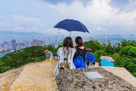 TAIPEI, TAIWAN - JUNE 11: This is the peak of Battleship rock which is a popular mountain in Taipei. Tourists watch the view as it begins to rain on June 11, 2017 in Taipeiのeditorial素材