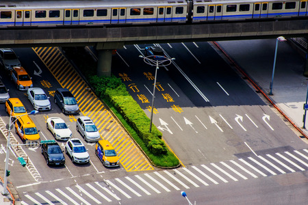 TAIPEI, TAIWAN - JUNE 21: This is an aerial view of a Taipei mrt train arriving in the station and a ctiy road with cars waiting at a traffic light on June 21, 2017 in Taipeiのeditorial素材