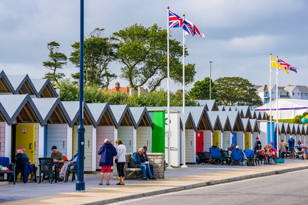 SWANAGE, UNITED KINGDOM - SEPTEMBER 07: This is a view of Swanage beach huts with people relaxing and sitting outside on September 07, 2017 in Swanageのeditorial素材