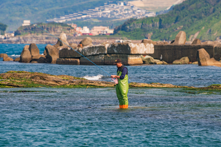 KEELUNG, TAIWAN - APRIL 04: Fisherman catching fish in the ocean near Badouzi coastal park on April 04, 2017 in Keelungのeditorial素材