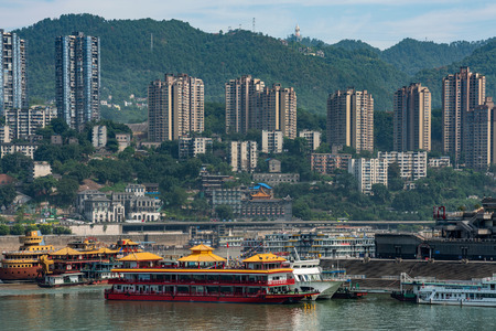 CHONGQING, CHINA - SEPTEMBER 19: River view of boats at Chaotianmen dock with hillside city buildings on September 19, 2018 in Chongqingのeditorial素材