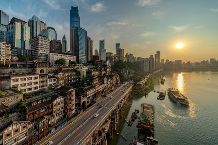 CHONGQING, CHINA - SEPTEMBER 19: Riverside view of Hongya Cave and high rise city buildings in the downtown area during sunset on September 19, 2018 in Chongqingのeditorial素材