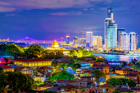 XIAMEN, CHINA -OCTOBER 11: This is a night view of Gulangyu Island old buildings with Xiamen modern city buildings in the distance on October 11, 2018 in Xiamenのeditorial素材