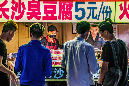 GUANGZHOU, CHINA - OCTOBER 22: People buying food at night market street food vendors on Sanxiajiu Pedestrian Street on October 22, 2018 in Guangzhouのeditorial素材