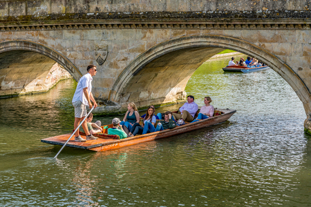 CAMBRIDGE, UNITED KINGDOM - APRIL 18: View of a punting boat under a traditional historic bridge along the river cam on April 18, 2019 in Cambridgeのeditorial素材