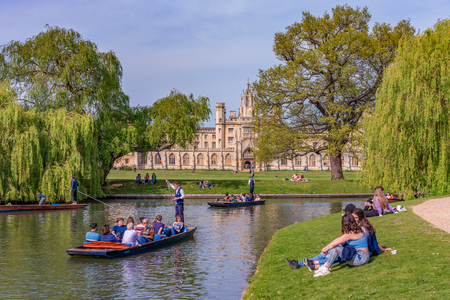 CAMBRIDGE, UNITED KINGDOM - APRIL 18: Scenic view of traditional punt boats along the River Cam with traditional British architecture in the distance on April 18, 2019 in Cambridgeのeditorial素材