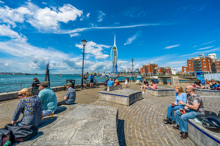 PORTSMOUTH, UNITED KINGDOM - MAY 25: People sitting at the waterfront area with the Spinnaker Tower building in the distance on May 25, 2019 in Portsmouthのeditorial素材
