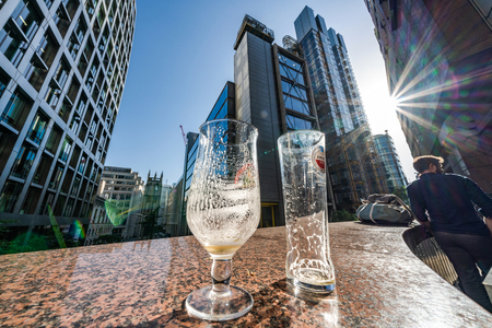 LONDON, UNITED KINGDOM - JUNE 27: Empty pint glasses on Bastion Highwalk with City buildings in the financial district on June 27, 2019 in Londonのeditorial素材