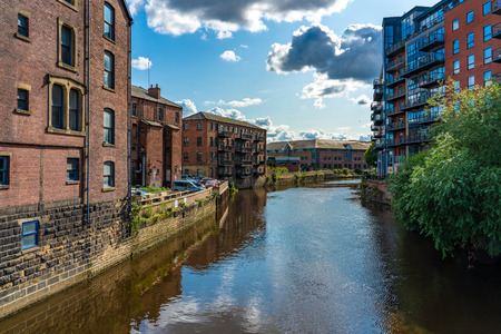 LEEDS, UNITED KINGDOM - AUGUST 13: View of the River Aire waterway with old riverside city buildings on August 13, 2019 in Leedsのeditorial素材