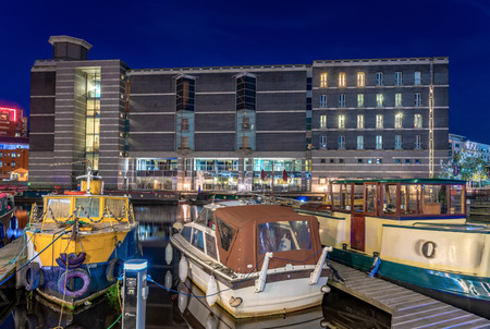 LEEDS, UNITED KINGDOM - AUGUST 13: Night view of boats anchored on the canal outside the famous Royal Armouries Museum on Leeds Dock on August 13, 2019 in Leedsのeditorial素材