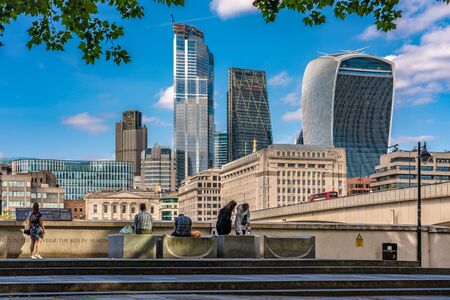 LONDON, UNITED KINGDOM - AUGUST 22: Riverside park view by London Bridge with the City of London Skyscrapers in the distance along the River Thames on August 22, 2019 in Londonのeditorial素材
