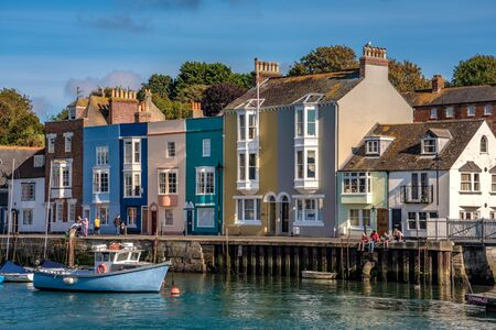 WEYMOUTH, UNITED KINGDOM - AUGUST 30: View of colourful houses along the waterfront at the historic Weymouth harbour on August 30, 2019 in Weymouthのeditorial素材
