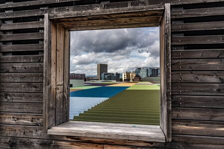 FRANKFURT, GERMANY - SEPTEMBER 25: View of colorful rooftop through a wooden window frame at the Skyline Plaza sky garden on September 25, 2019 in Frankfurtのeditorial素材