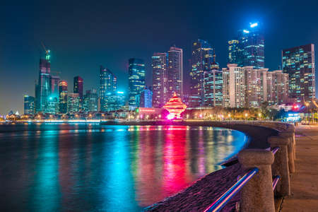 QINGDAO, CHINA - NOVEMBER 13: Night view of the Qingdao financial district skyscrapers along the waterfront on November 13, 2019 in Qingdao