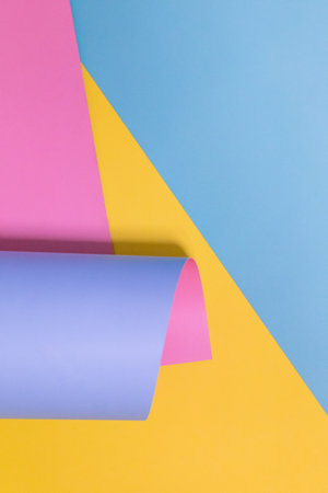 Blue, yellow, pink and purple colored paper. Geometric empty background, copy space