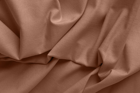 Textured folds of linen fabric in natural brown color. Textile background, top view, copy spaceの写真素材