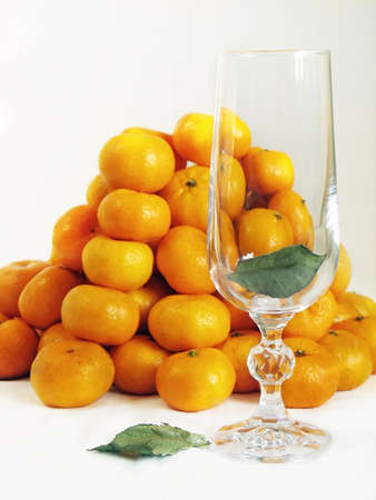 Glass with listikom against the backdrop of slides Mandarin.の写真素材