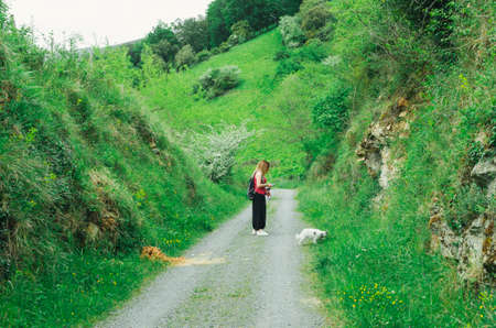 woman walking dog on leash in the park