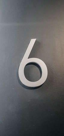 Vertical shot of number Six on the gray wallの写真素材