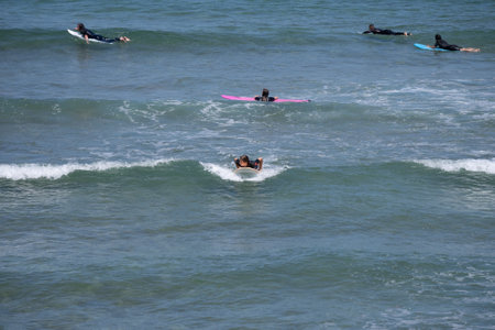 Guipuzkoa, Zarautz, Spain - 09, July, 2022: Group of surfers on the beaches of Zarautz.