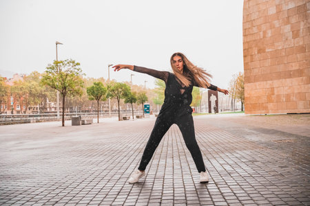Carefree woman dancing on streetCarefree woman dancing on the street in the rainの写真素材