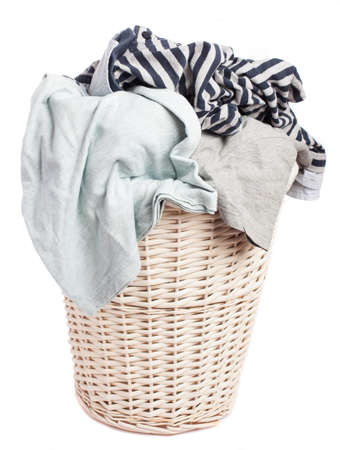 dirty clothes in a basket on a white backgroundの写真素材