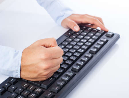 stressed man at computer on a white background