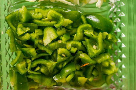 Green chilli in plastic box close-up, selective focus.