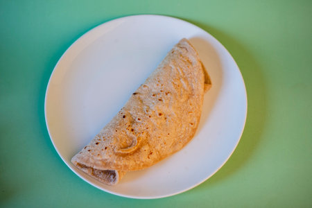 Crepes on a white plate on a green background, top viewの写真素材
