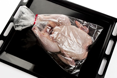 fresh chicken into a oven bag on a baking trayの写真素材