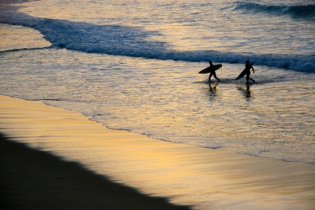 surfers out of the water at sunset in San Sebastian, Basque Country