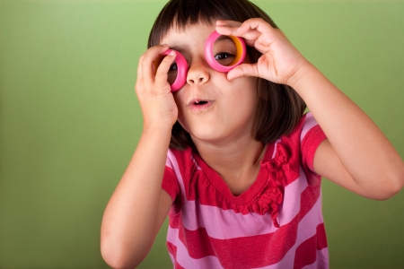 funny little girl pretending she wears eyeglassesの写真素材