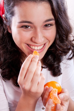 Beautiful and happy girl eating tangerines.の写真素材