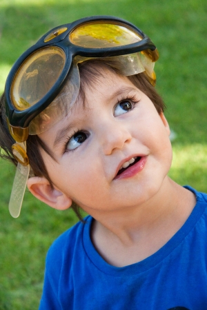 Portrait of a cute little boy with goggles looking intently upの写真素材