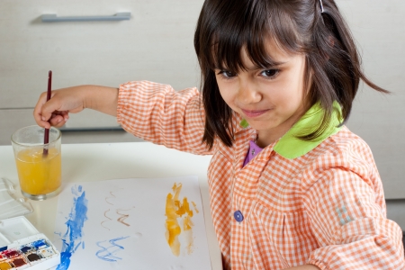 Cheerful little girl painting with watercolorsの写真素材