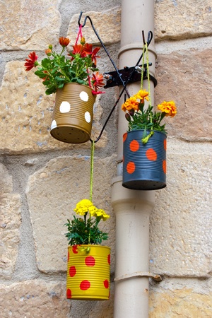 Hanging flowerpots made with cans in the street の写真素材