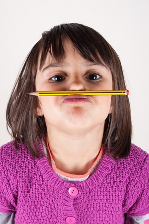 Naughty little girl holding a pencil like a mustache  Concept of education の写真素材