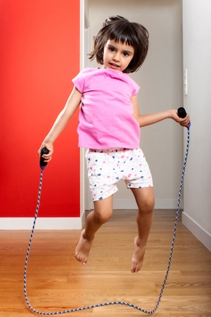 Little girl jumping rope at homeの写真素材