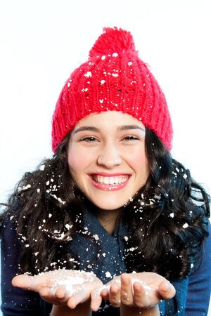 Happy young woman with fake snow in hands, face and hair laughingの写真素材