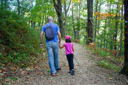Father and daughter walking in the forest in autumnの写真素材